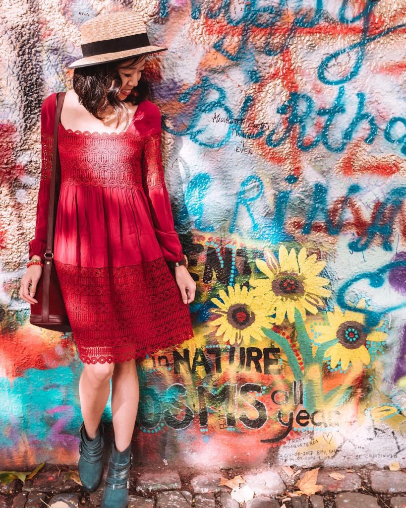 photo of girl in front of the lennon wall artwork in prague