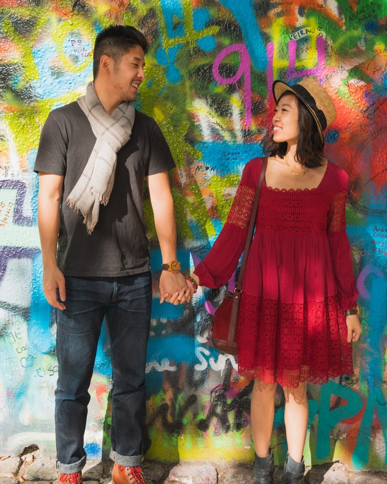 photo of couple in front of the lennon wall artwork in prague