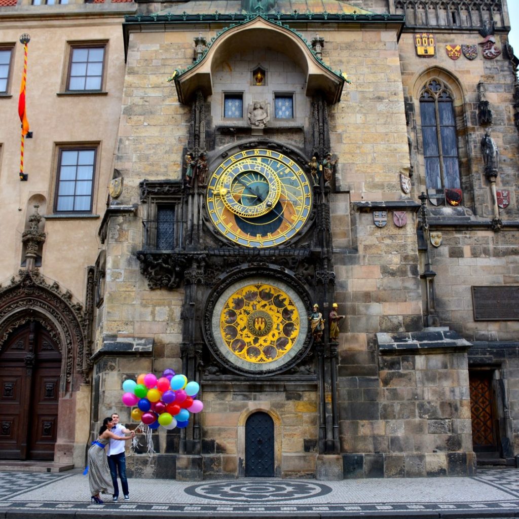 couple in front of astronomical clock in prague