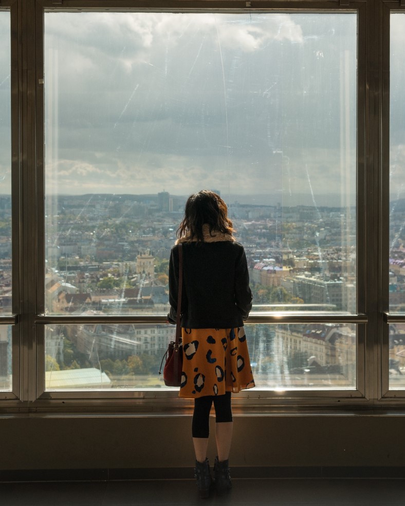 girl looking out the window on top of zizkov tower