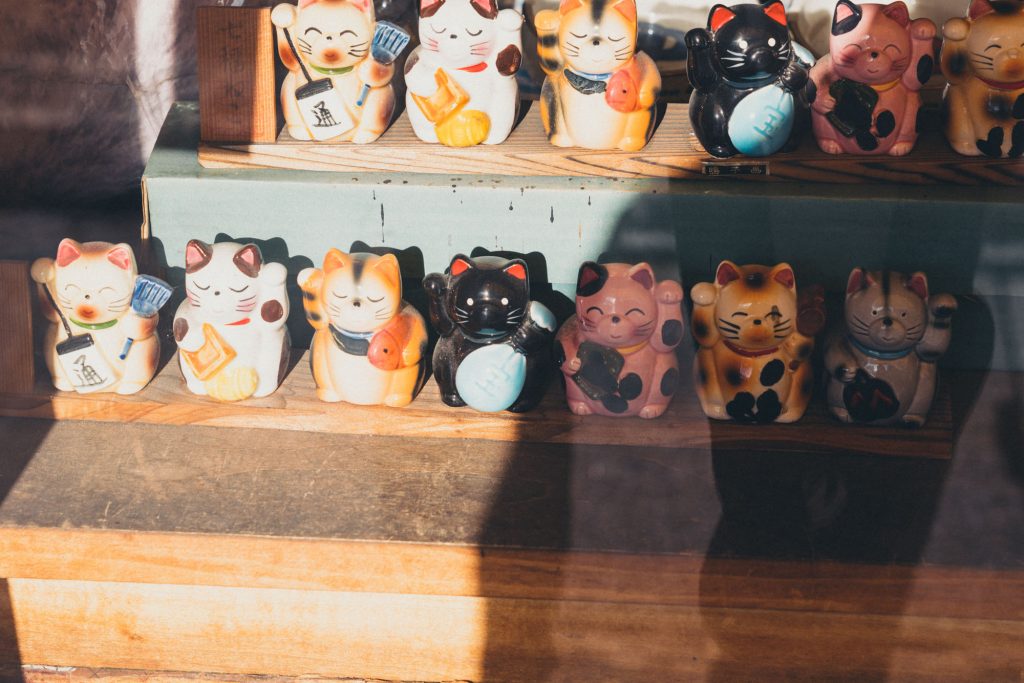 image of a few maneki neko on a shelf