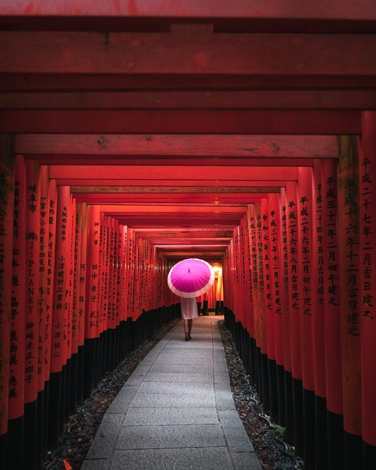 girl with umbrella hiking up fushimi inari