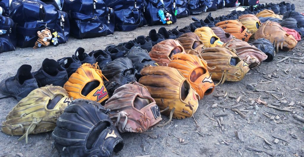 line of baseball gloves on the ground