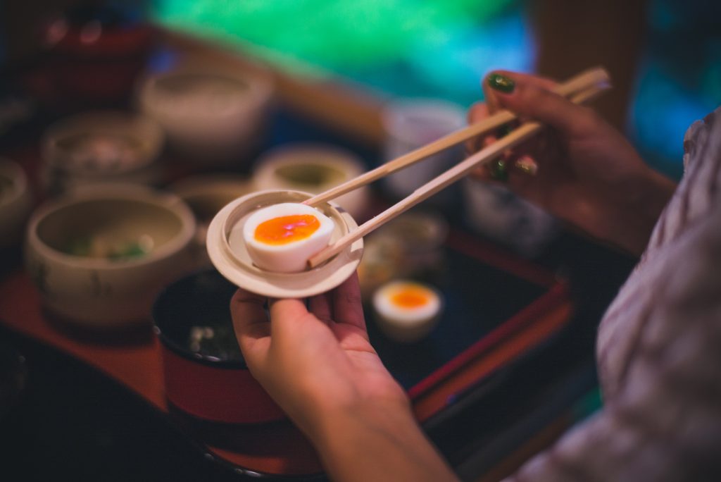 picture of person holding eggs with chopsticks in japan