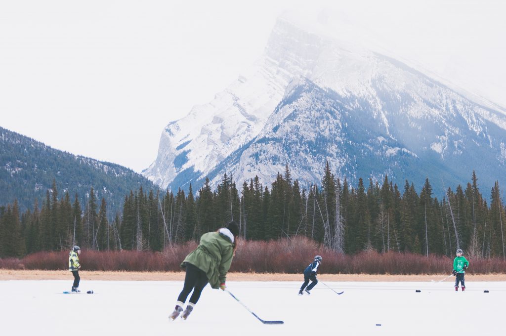 photo of people playing hockey in front of a mountain