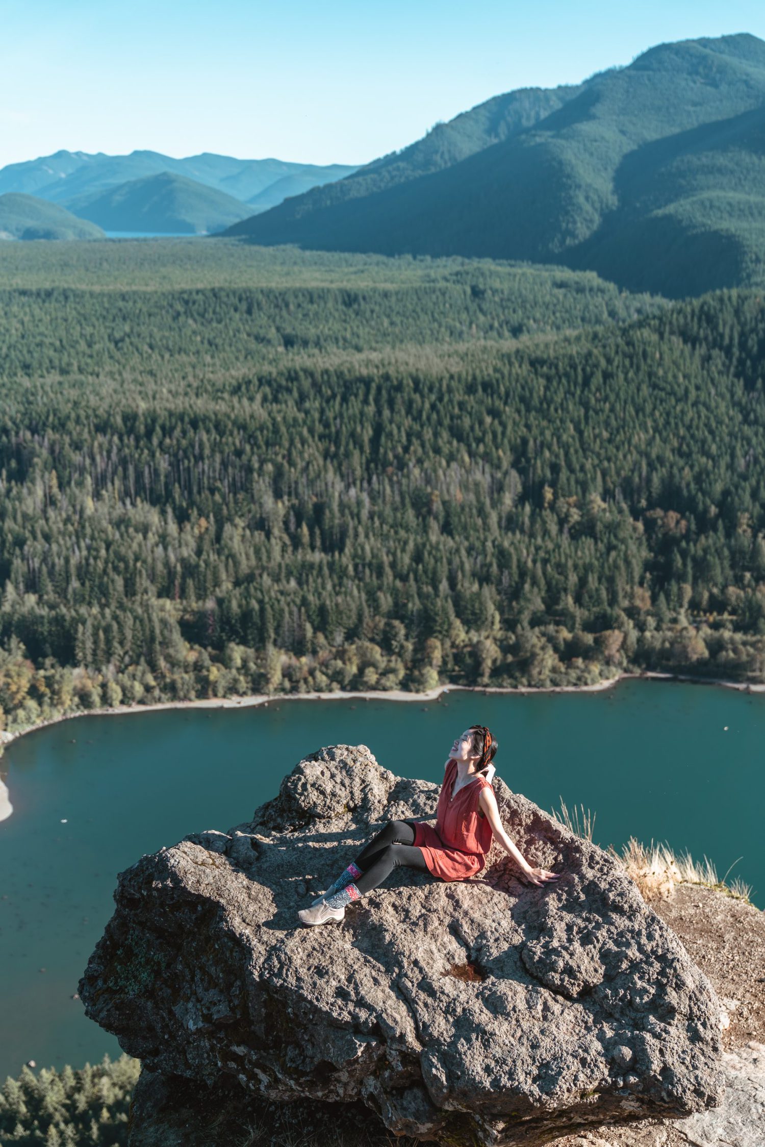 Girl sitting on top of large rock overlooking lake at Rattlesnake Ledge