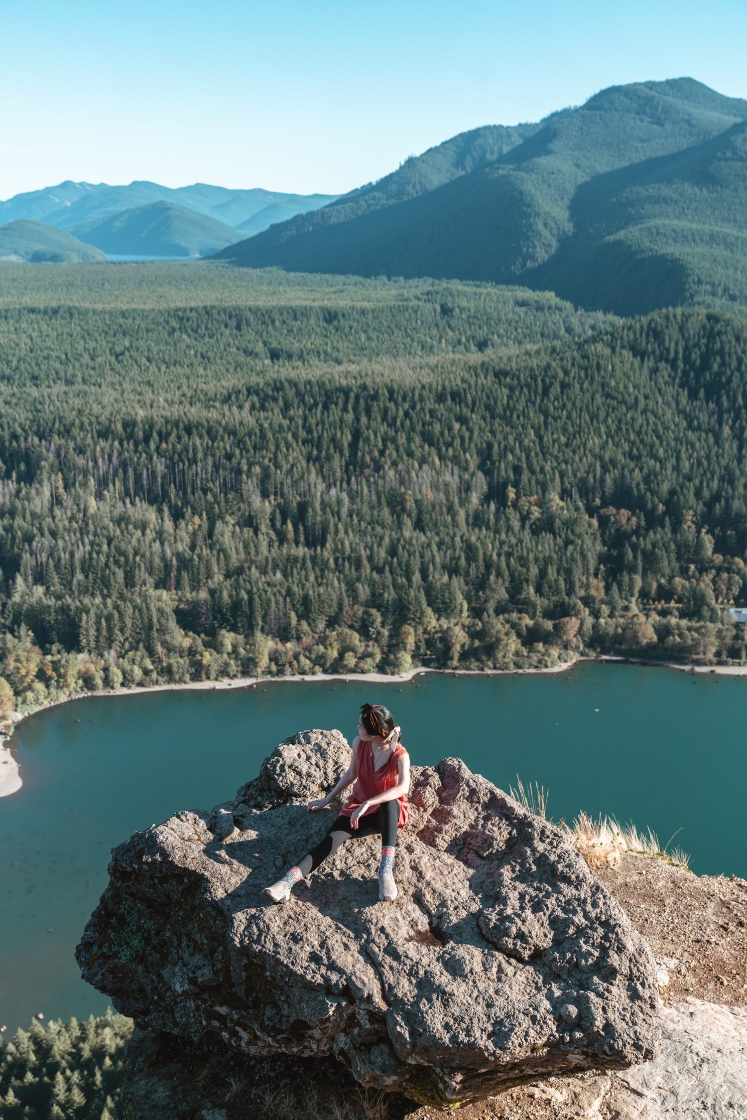 Girl sitting on top of large rock overlooking lake at Rattlesnake Ledge