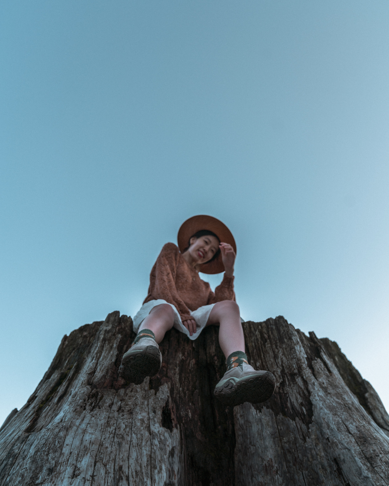 Girl sitting on log with feet dangling