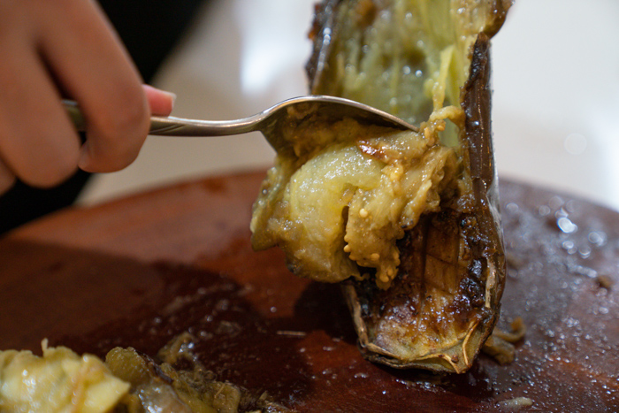 image of spooning the inside of an eggplant out