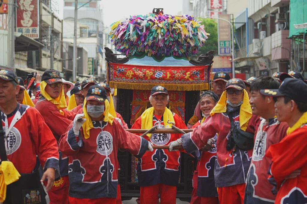 image of a group of people dressed in red carrying a palaquin