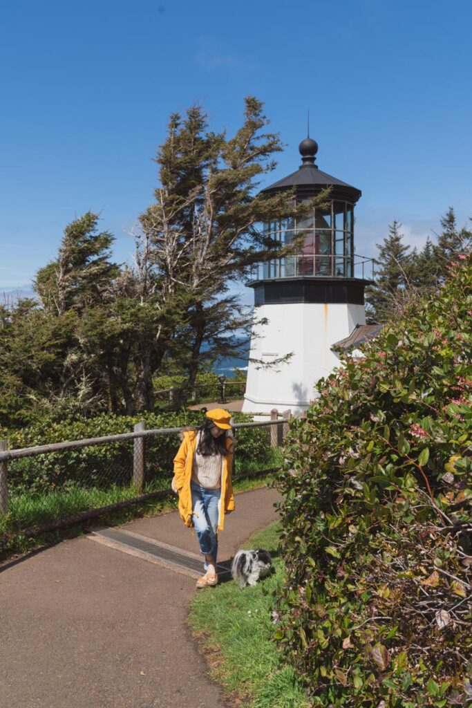 image of girl and a dog in front of cape meares lighthouse