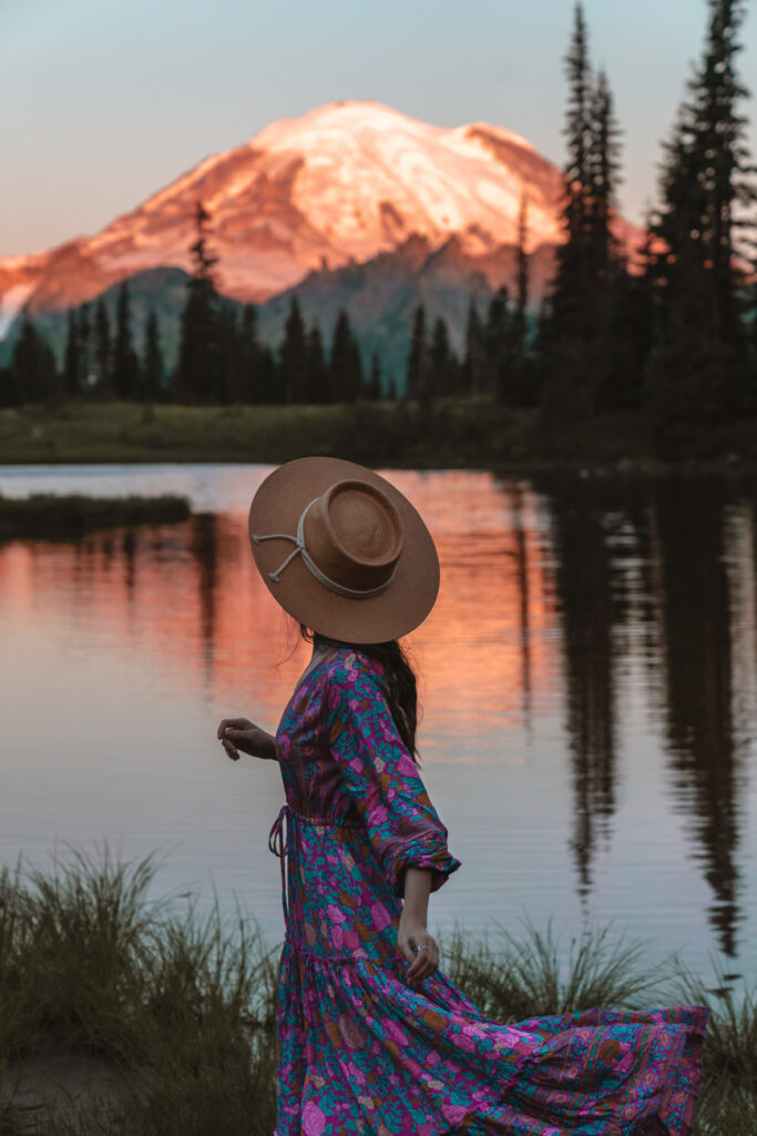 image of girl in front of rainier at sunrise with a lake 