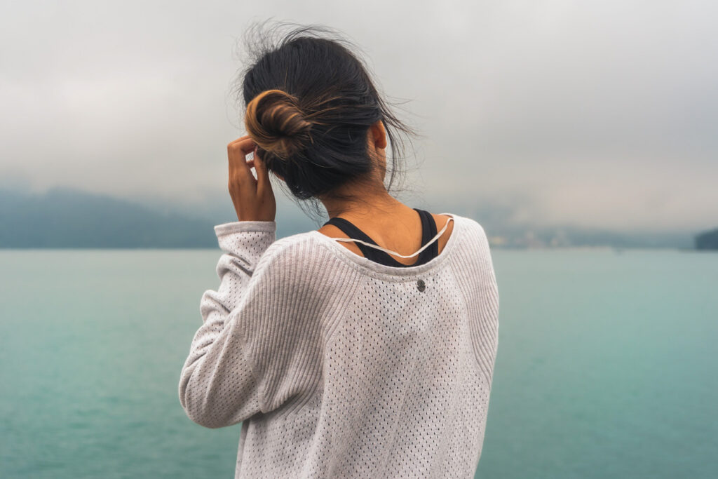 image of girl in front of a blue lake