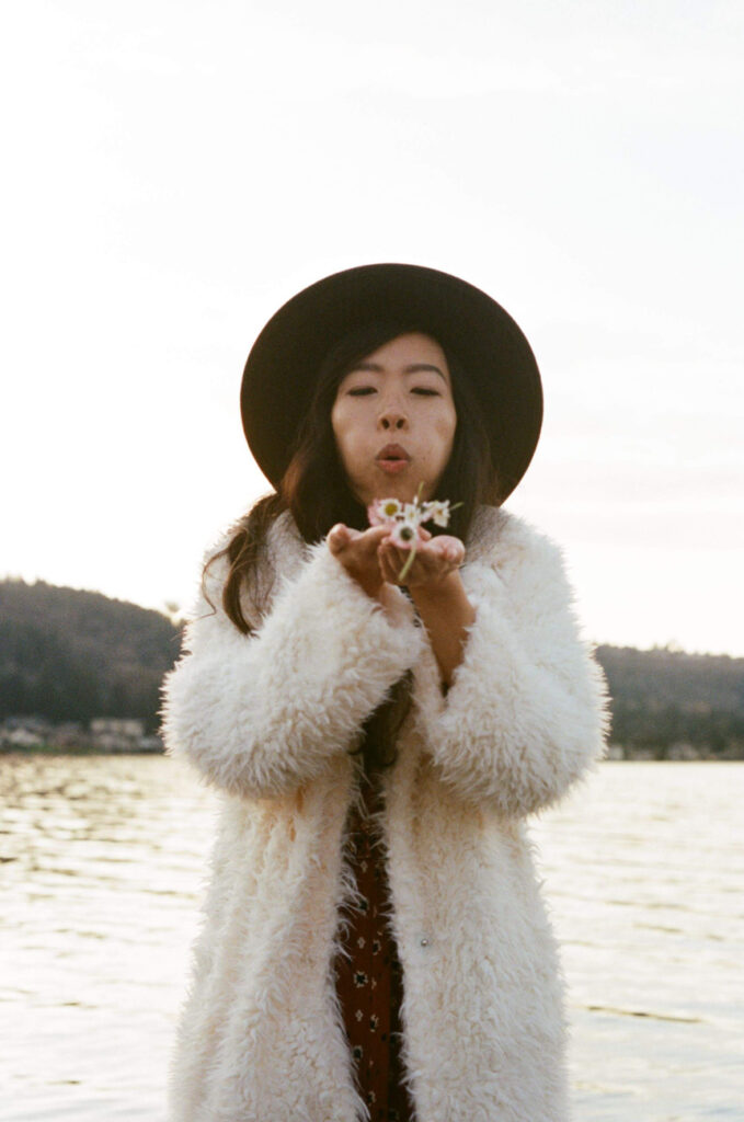 image of girl blowing flowers out of her hand