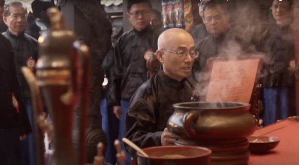 image of person in temple reading from scripture with smoke coming from incense